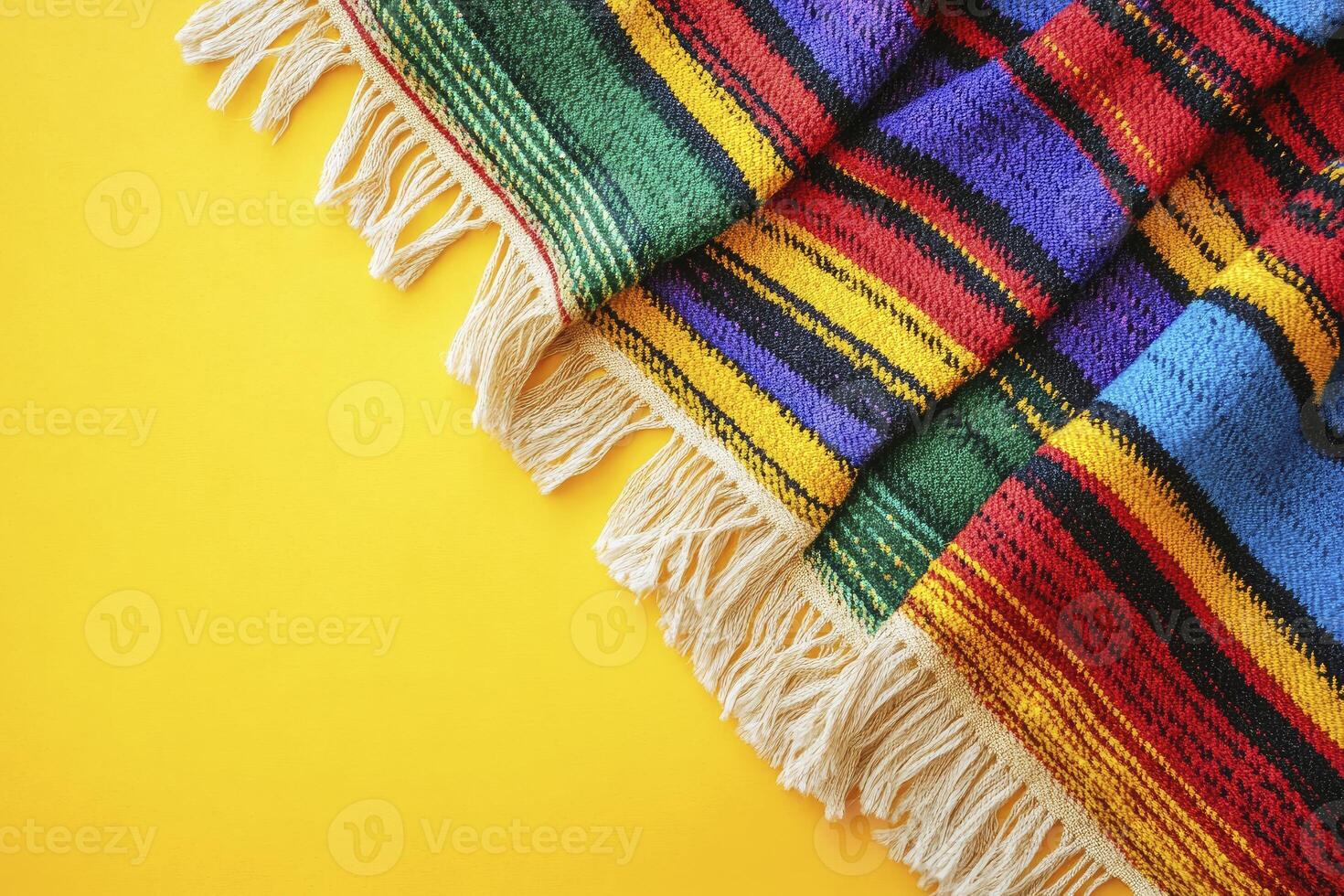 Colorful Striped Textile with Fringe on Bright Yellow Background photo