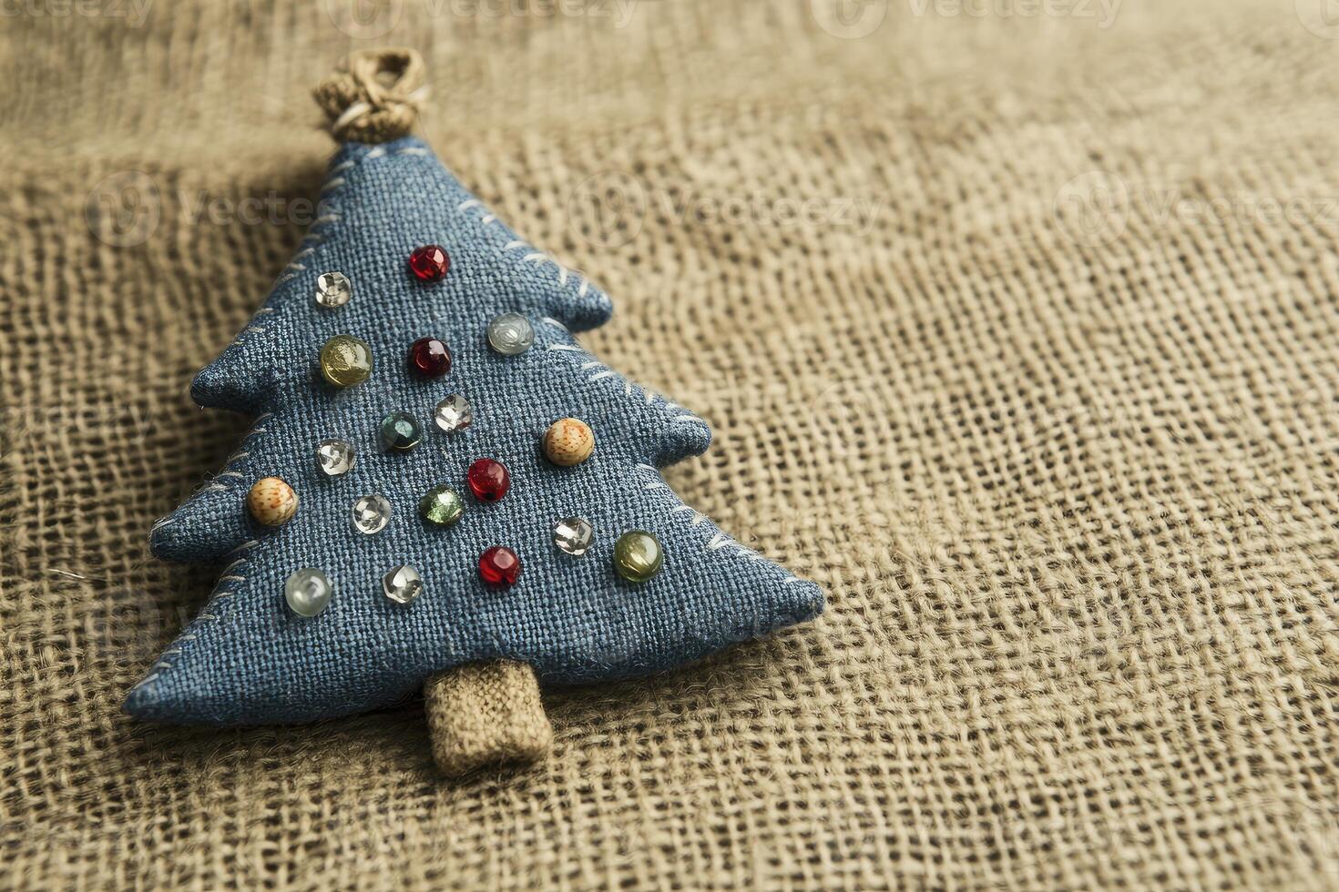 Festive Fabric Christmas Tree with Colorful Beads on Burlap Background photo