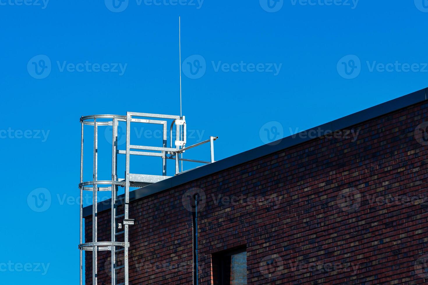 A metallic framework stands prominently on the rooftop of a brick photo