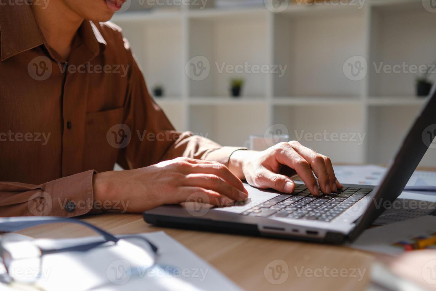 Close up of hands typing on a laptop keyboard, working on business analysis and online learning. photo