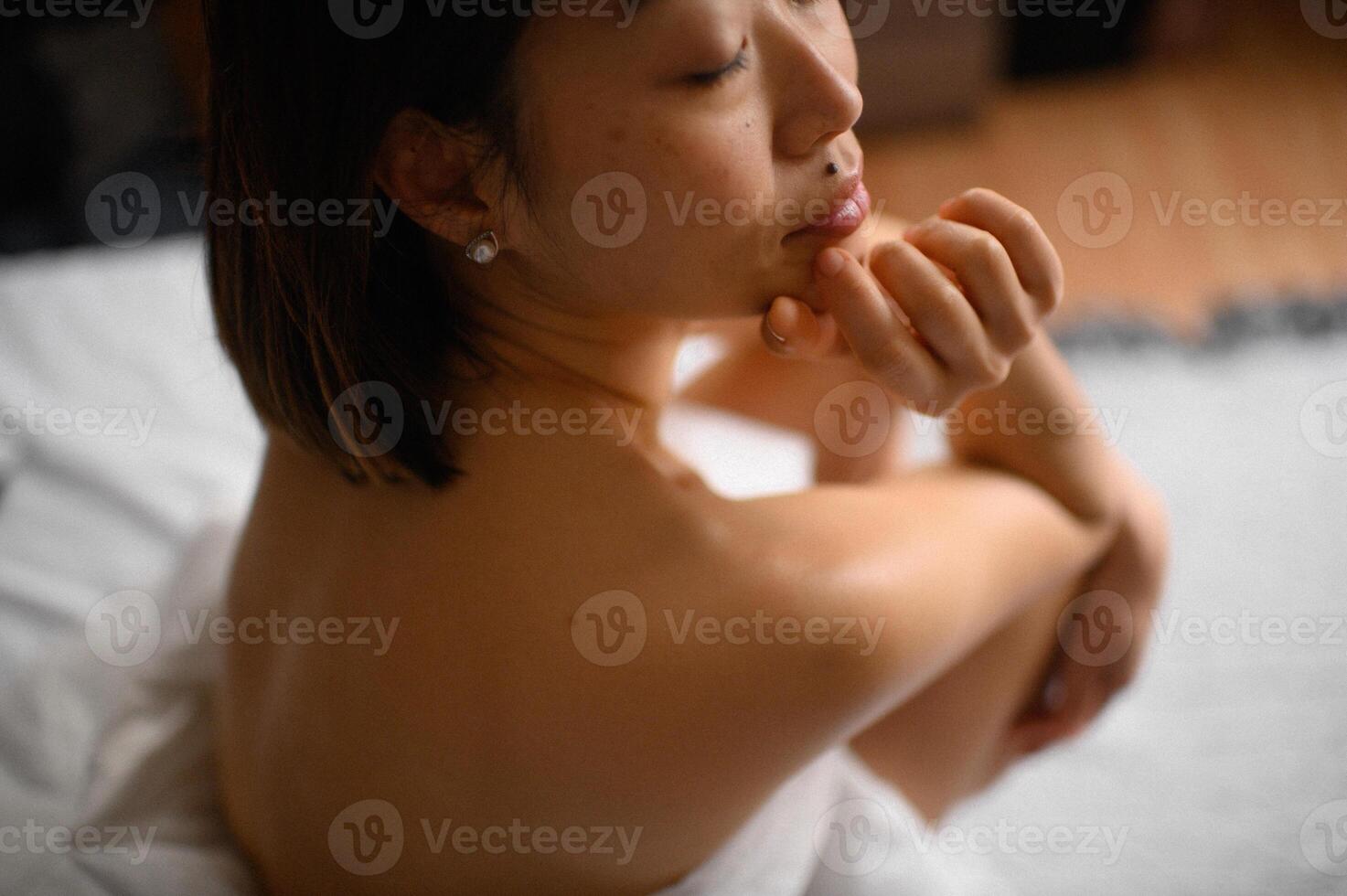 Her fingers lightly grasp the edge of the blanket, pulling it closer as she watches the world outside in silent contemplation. photo