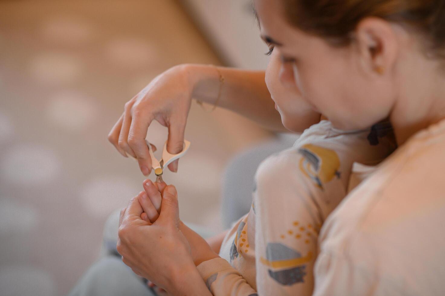 A mother uses special rounded tip scissors to neatly trim her child s fingernails. photo