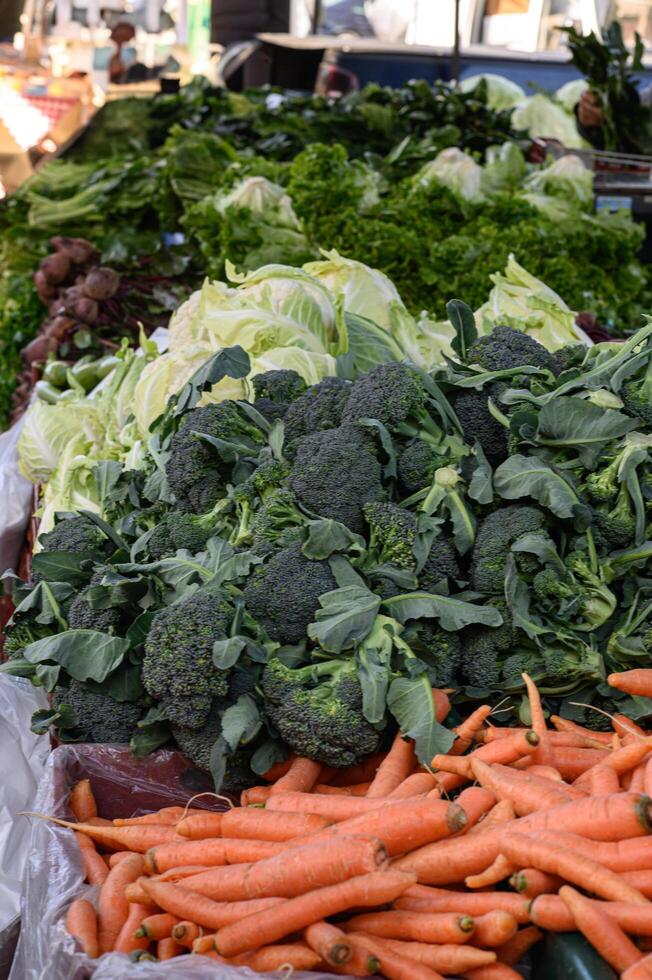 Farm-fresh vegetables, including leafy greens, root crops, and vibrant bell peppers, showcased at a bio market. photo