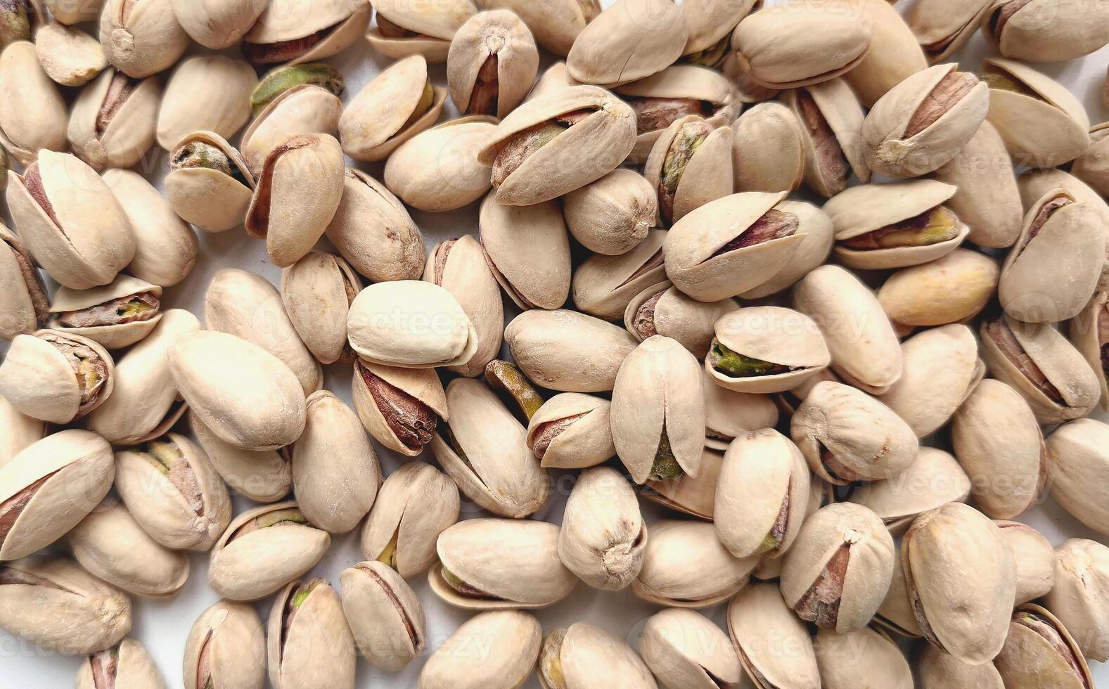 Top view of background with pistachio nuts. Appetizing dried nuts, rich in vitamins and microelements, are ready to eat. Vegetarian food photo