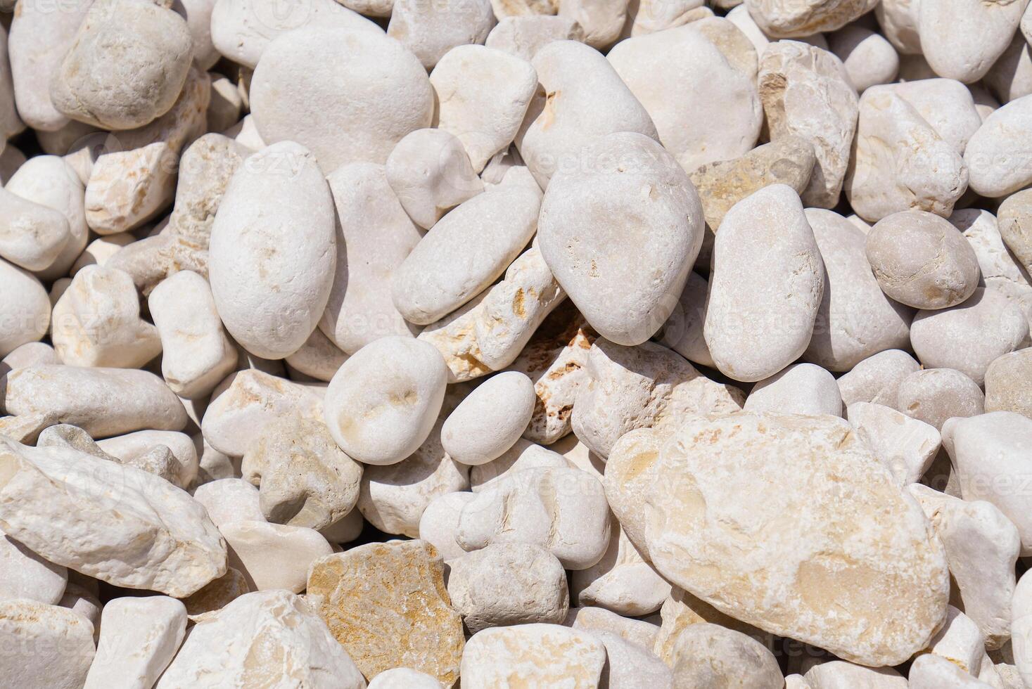 White pebbles background texture. Smooth round stones. Zen garden, spa, and meditation concept. Beach pebble stones. Perfect for a relaxing background or for use in a spa or meditation setting. photo