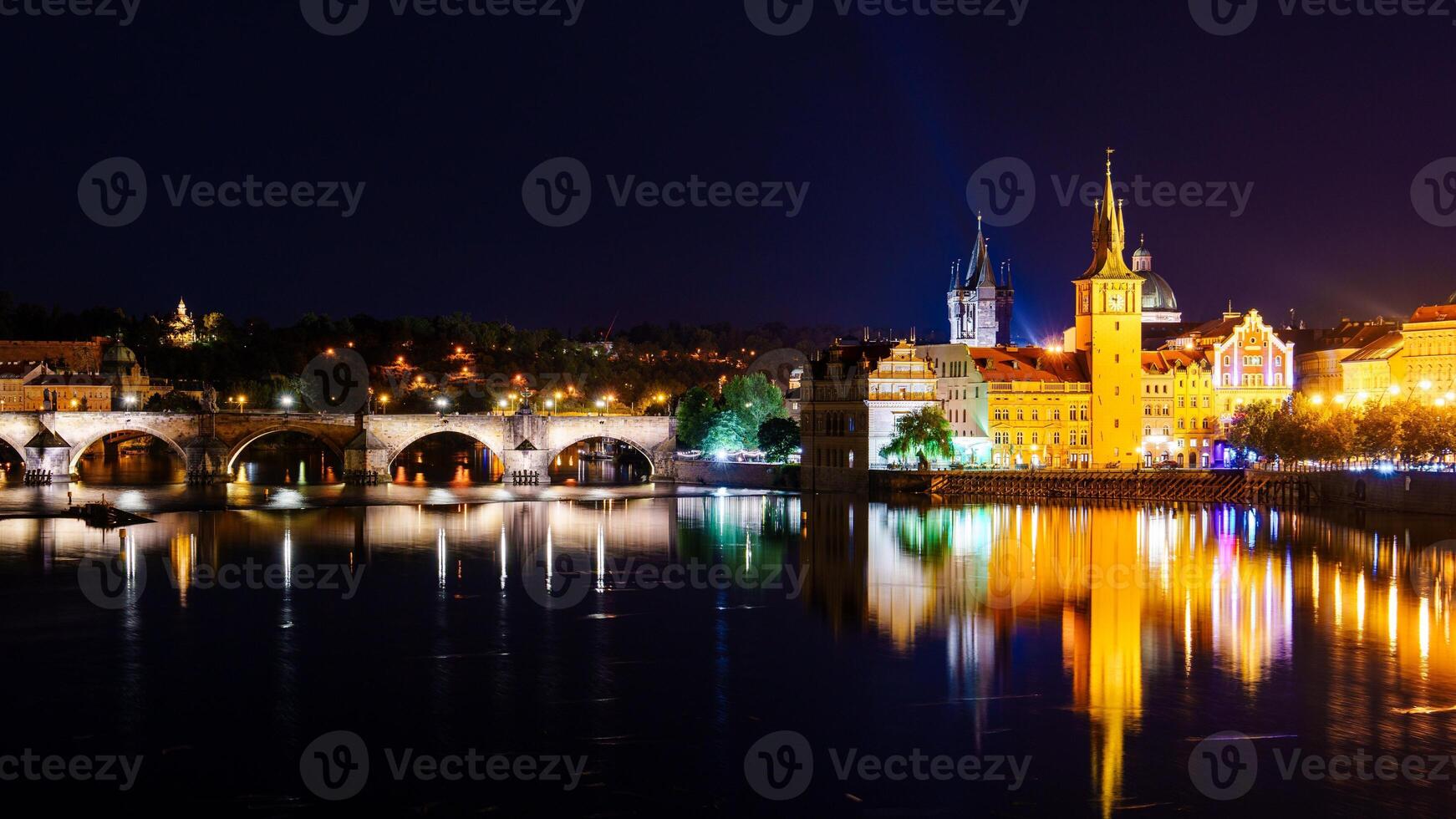 A breathtaking panoramic night view of Prague, featuring the illuminated Prague Castle, the historic Charles Bridge, and the serene Vltava River, creating a magical atmosphere in Prague. photo