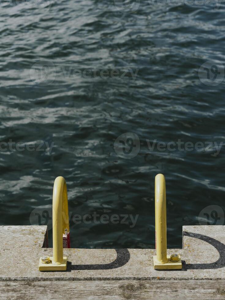 Looking through a bright yellow ladder to the beautiful boats moored in the harbor in Sopot, Poland. photo