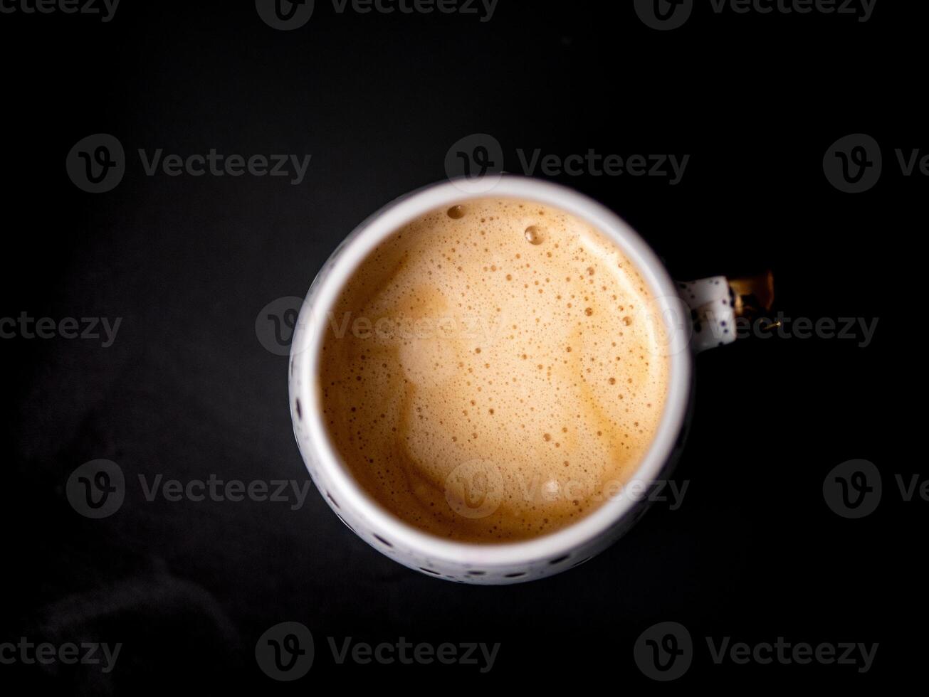 A white coffee cup with foam on top photo