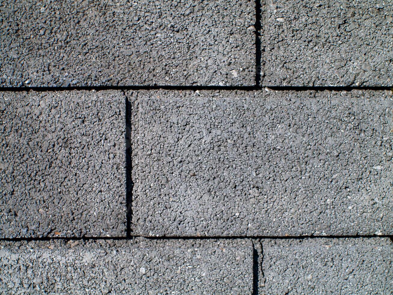 A gray brick wall with a black line in the middle photo
