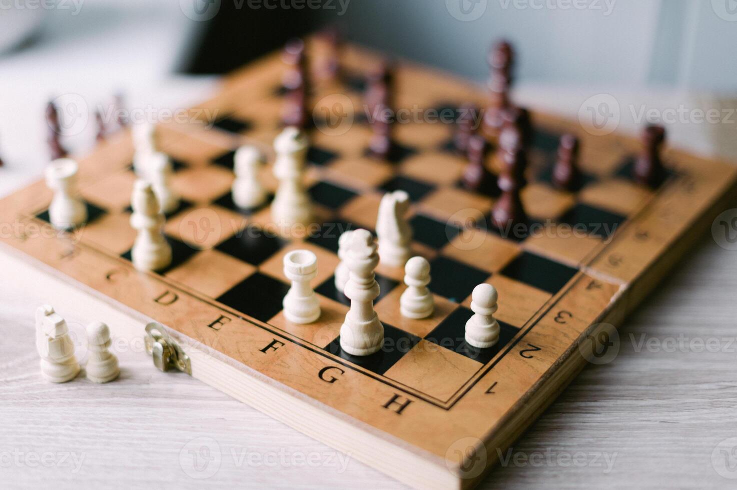 A wooden chess board with a few pieces on it photo