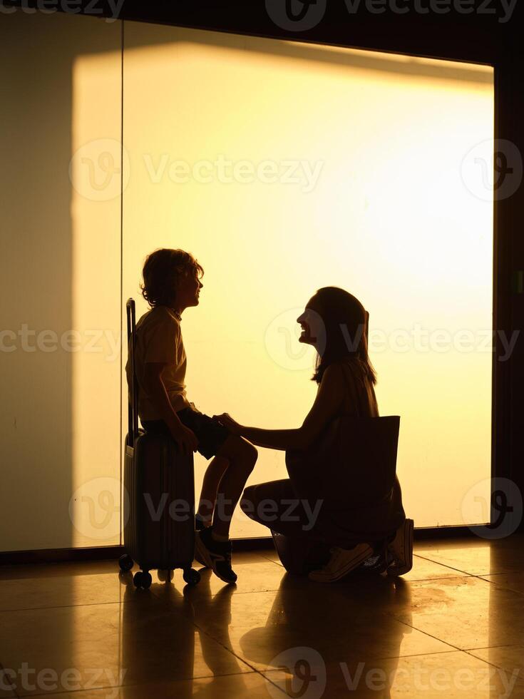 Anonymous woman and boy waiting for flight in airport photo