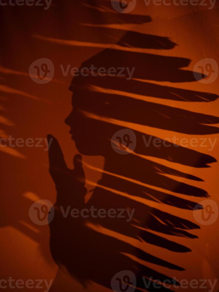 Shadow of anonymous boy in native American headwear photo