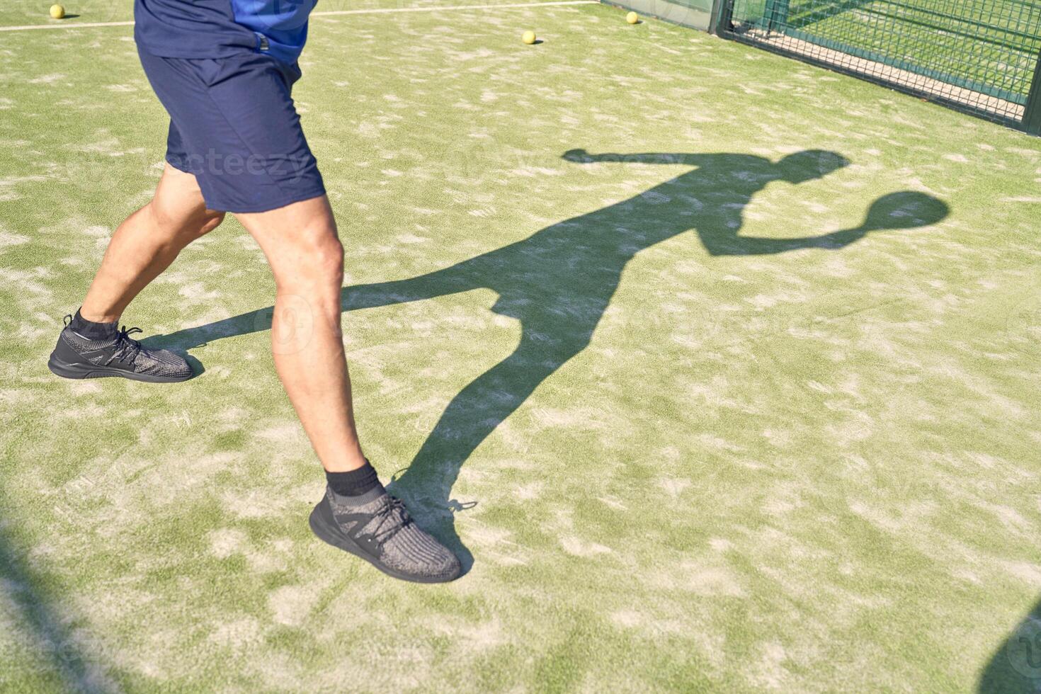 Crop sportsman exercising on tennis court photo