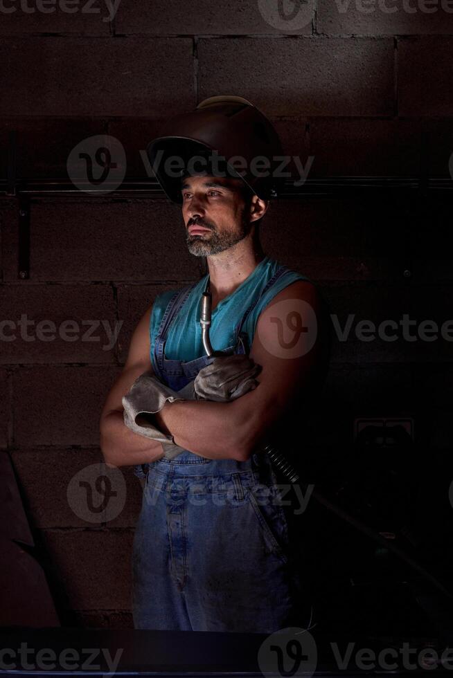 Confident man in welding helmet with arms crossed photo