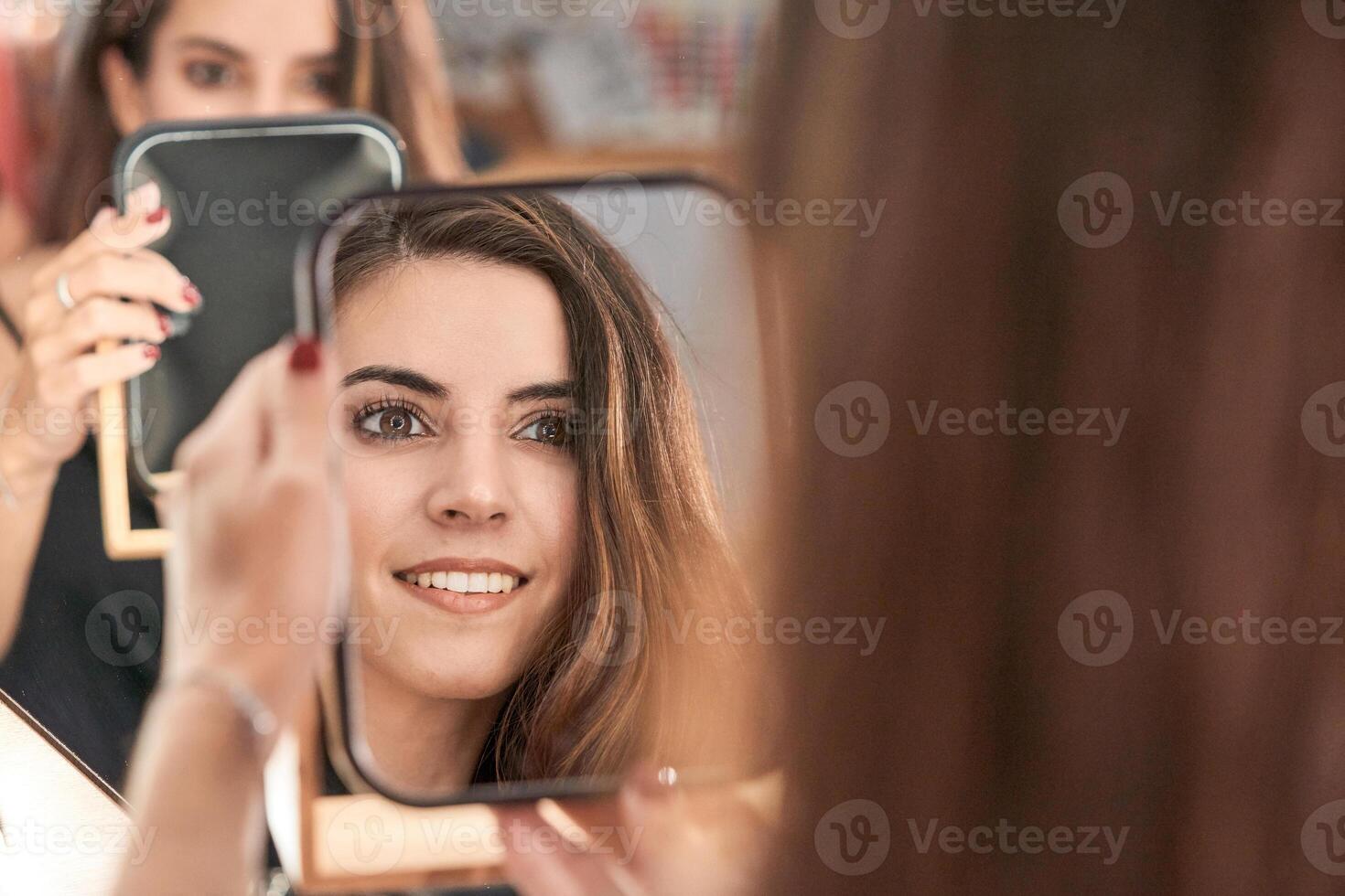 Content model looking at mirror in salon photo