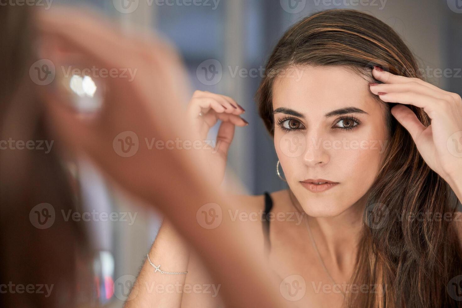 Attractive woman near mirror in studio photo