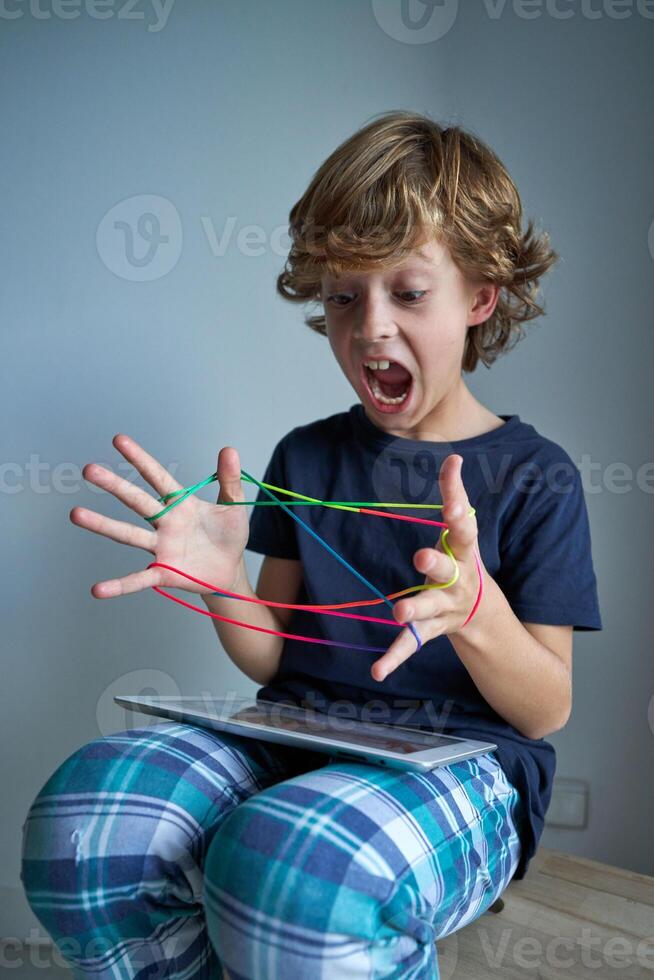 Boy screaming while playing string game photo