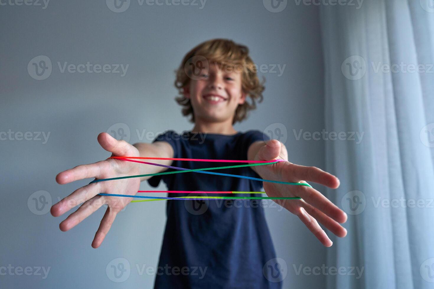 Smiling boy making string figures photo