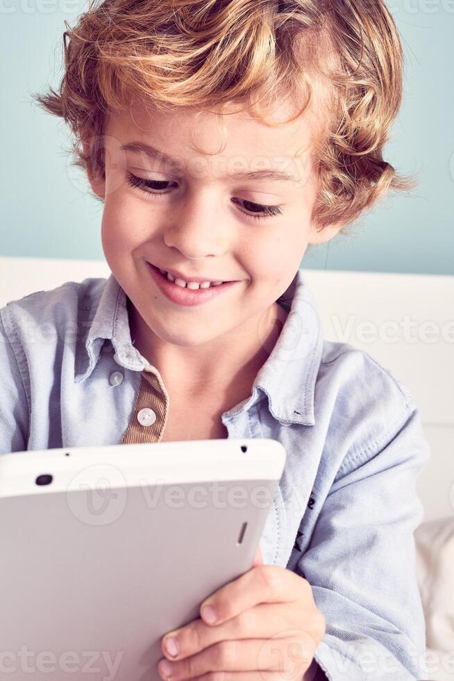 Smiling boy using tablet at home photo