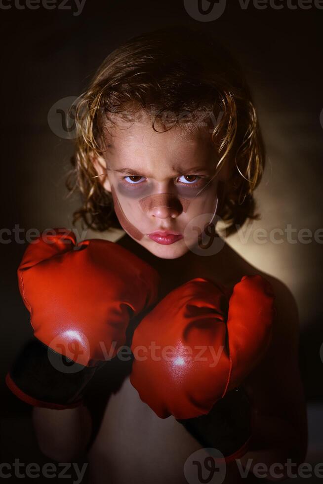 Boy with bruises in boxing gloves photo
