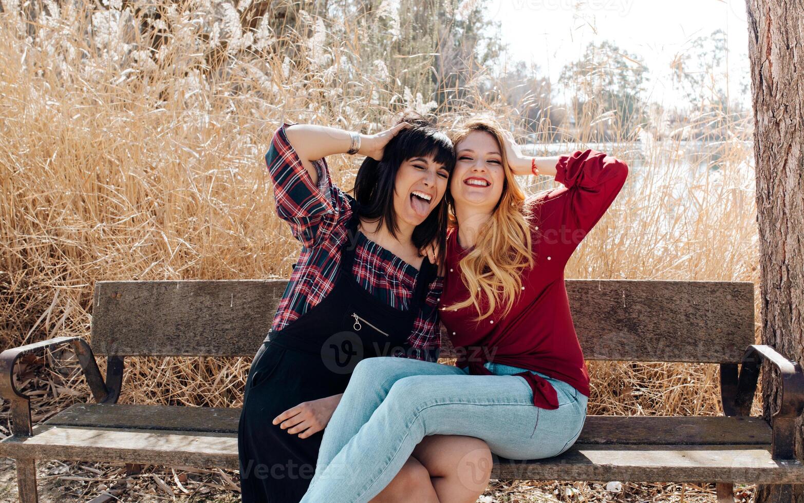 Young women sitting on bench and looking at camera photo