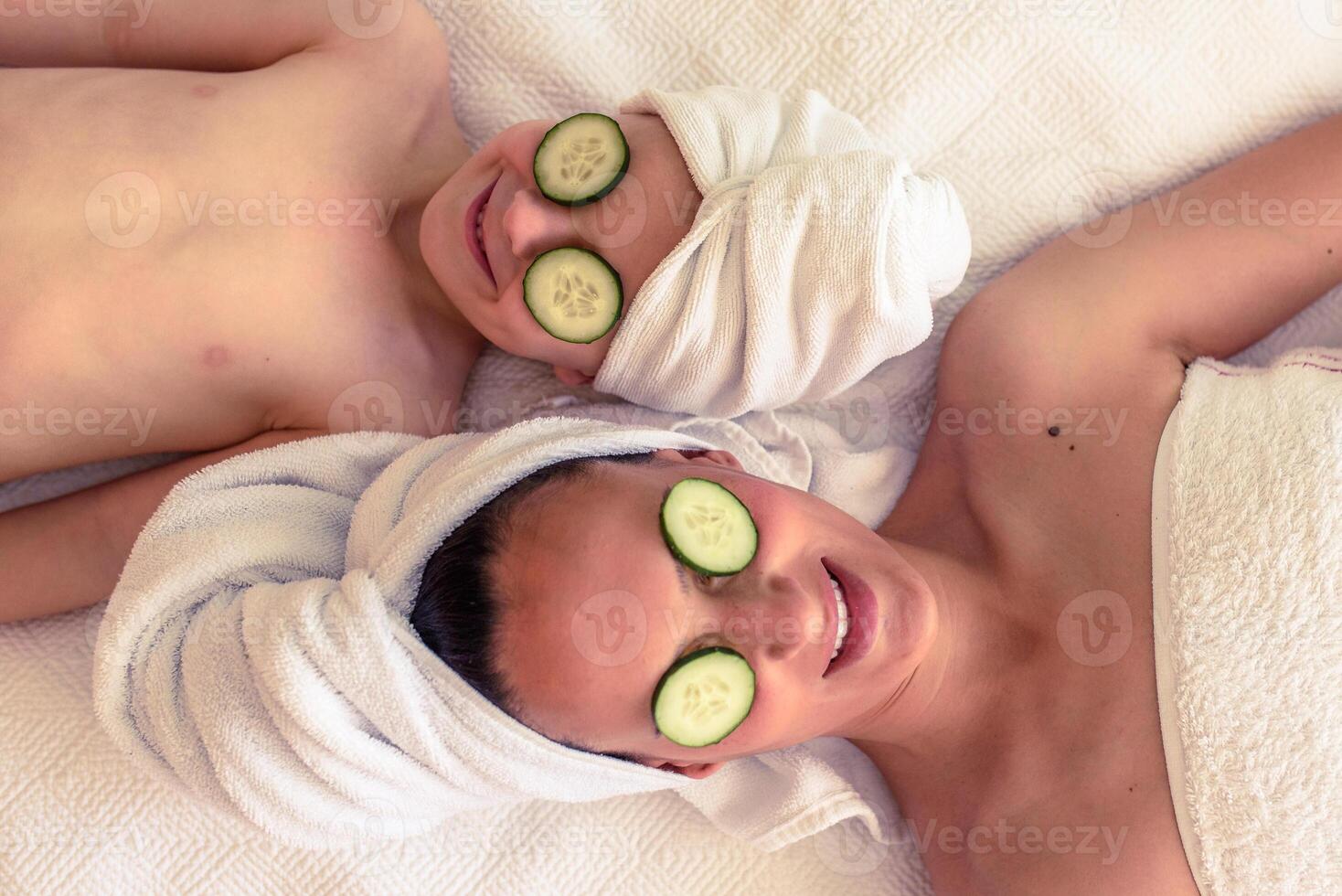Mother with son with cucumber on eyes photo