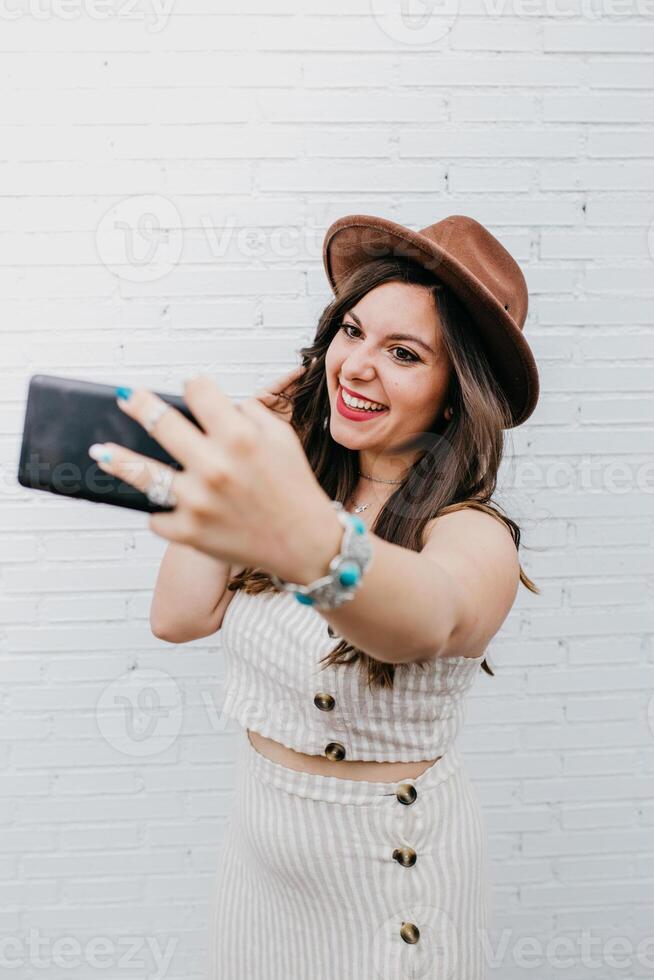 Woman smiling and taking selfie on smartphone photo