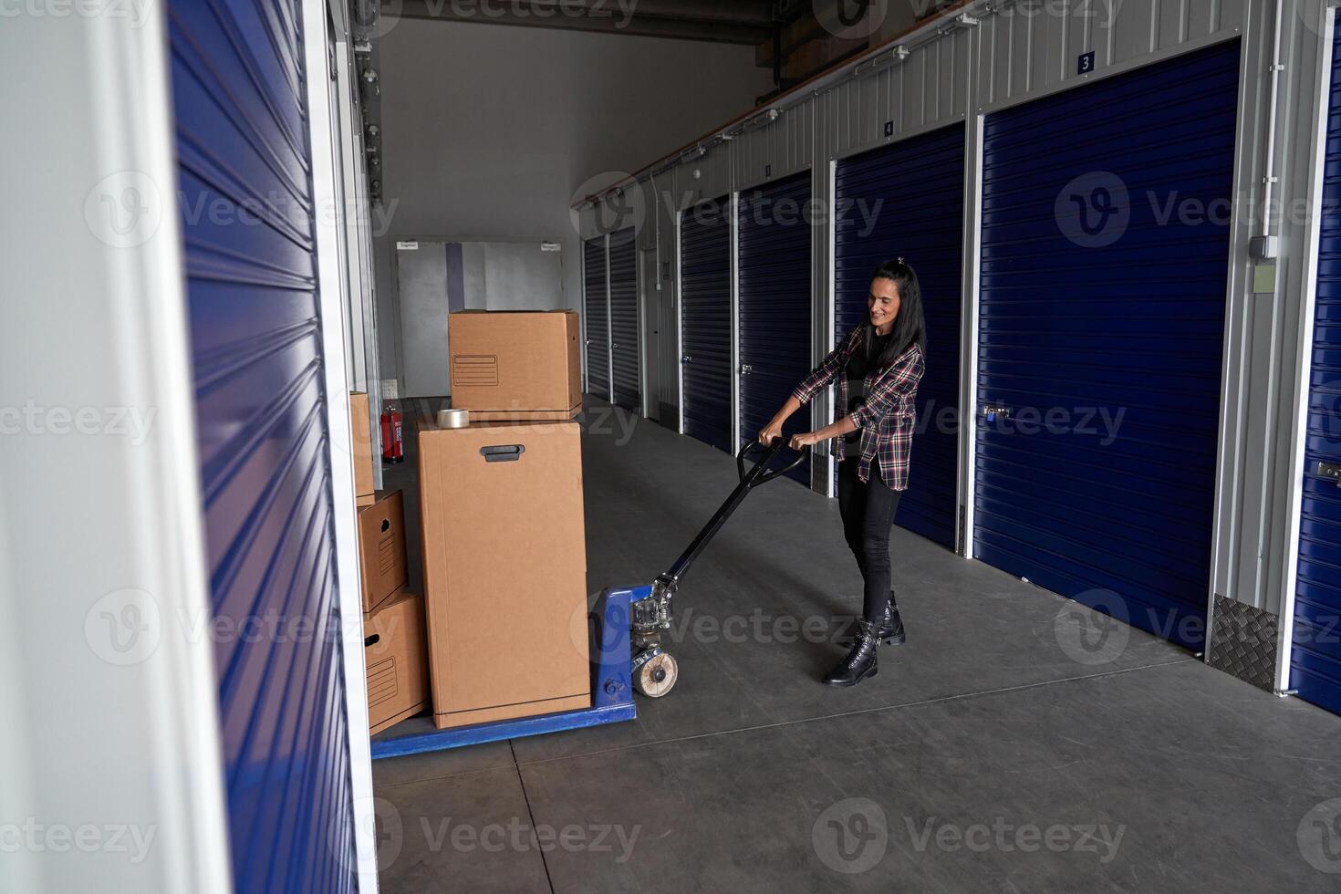 Woman rolling pallet truck with boxes photo