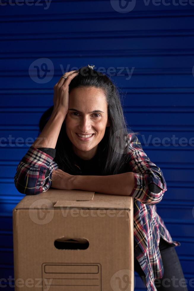 Smiling woman leaning on box photo