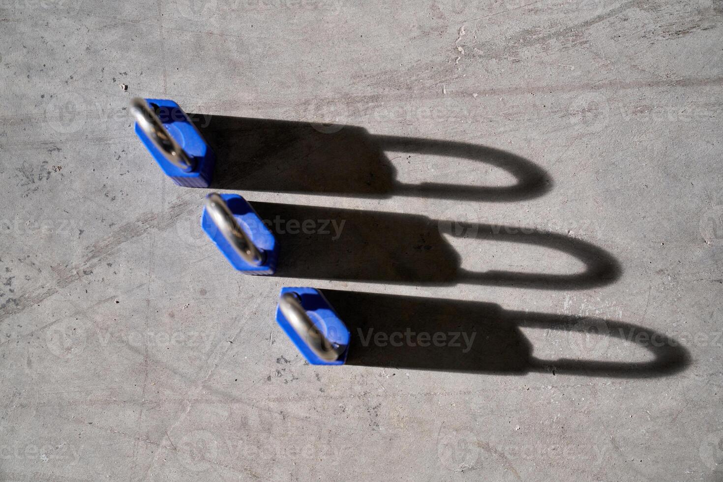 Set of secure locks placed on concrete floor photo