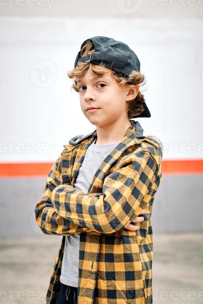 Child standing on street with crossed arms photo