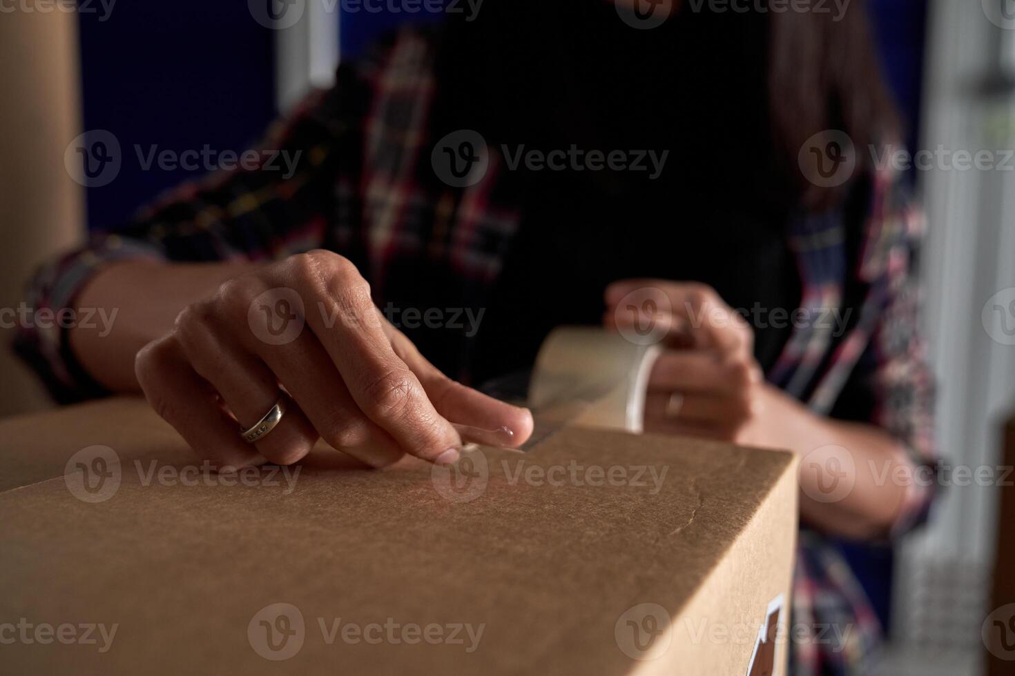 Unrecognizable woman taping carton box photo