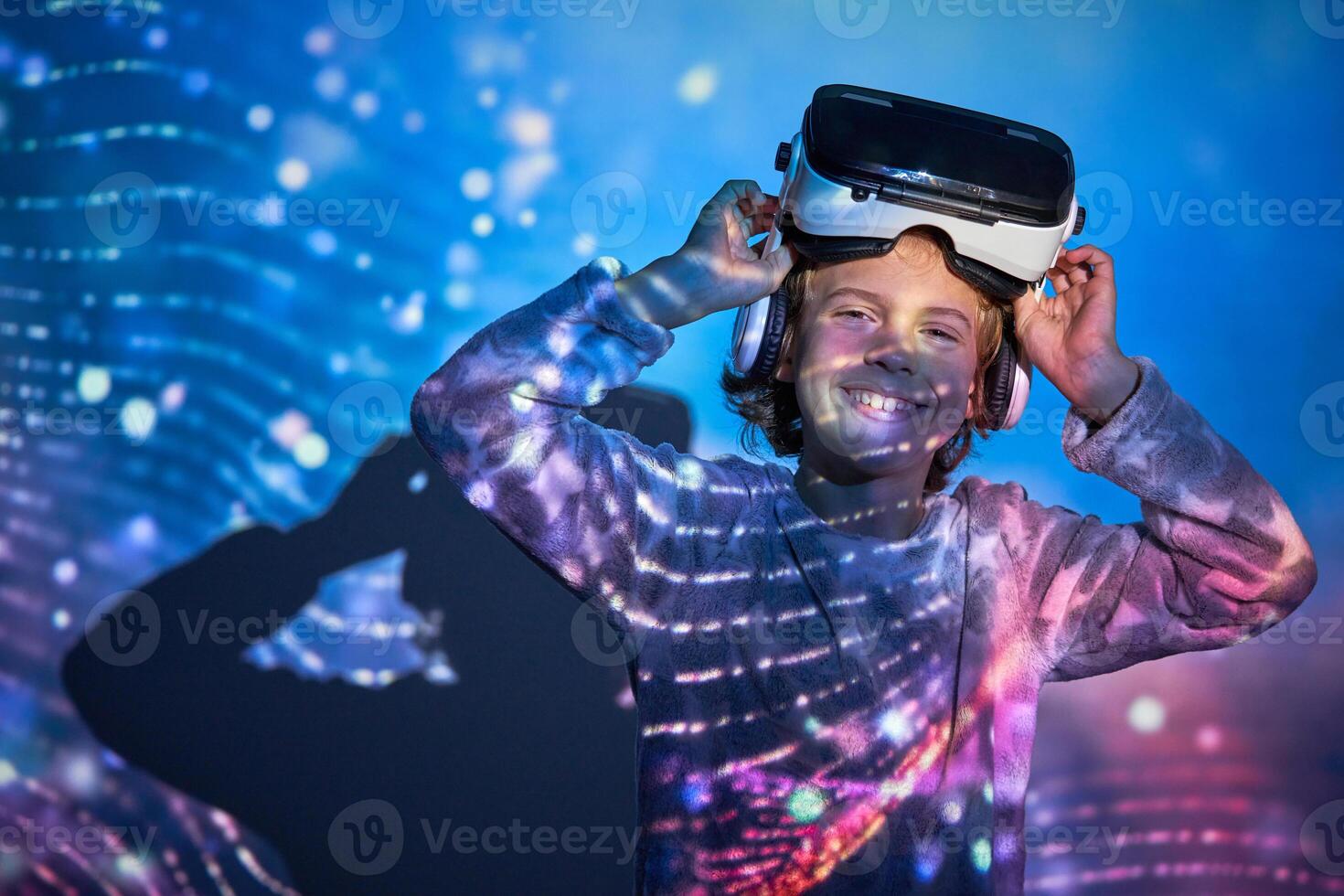 Cheerful child taking off VR headset and smiling at camera photo