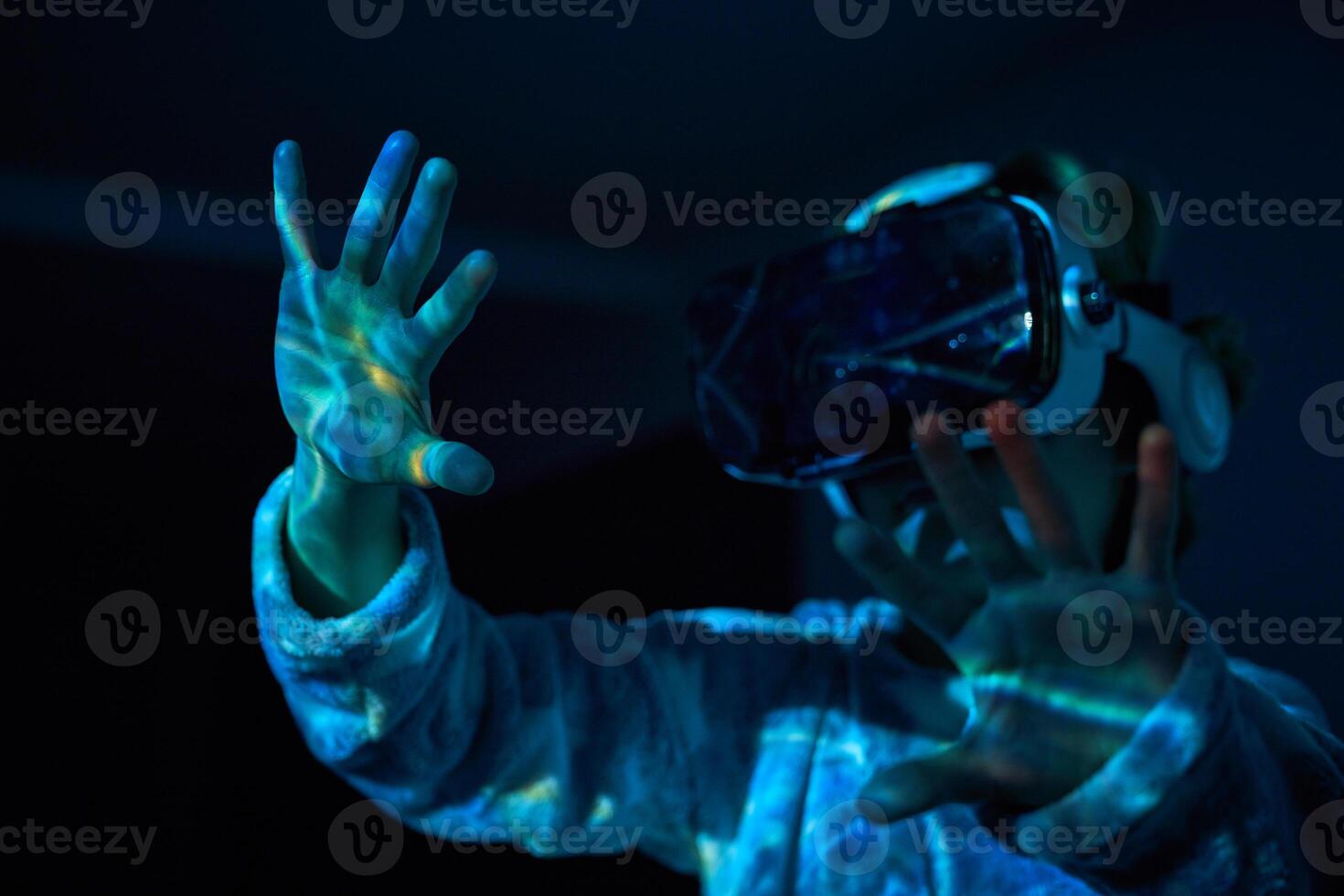 Anonymous child touching imaginary screen in VR glasses photo