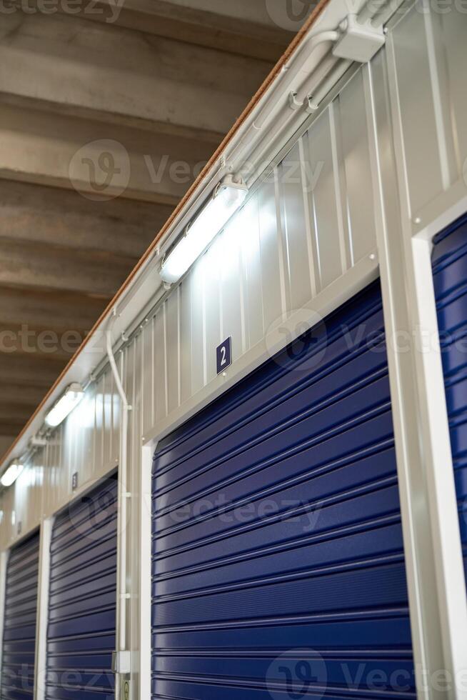 Row of blue roller shutters in modern warehouse photo