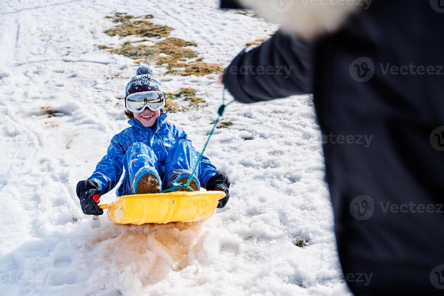 Crop parent pulling sleigh with merry kid photo