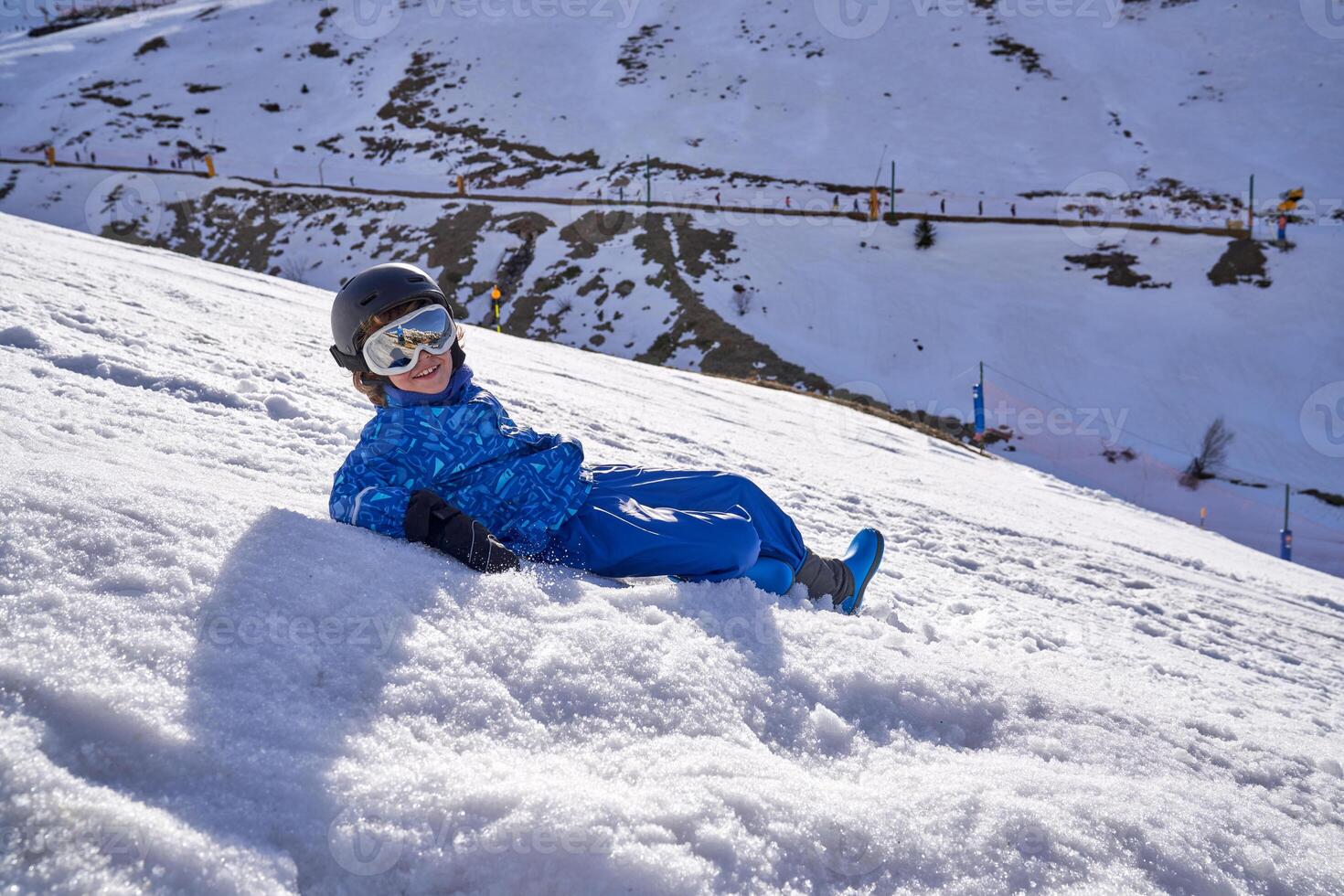 Child lying on snowy slope photo