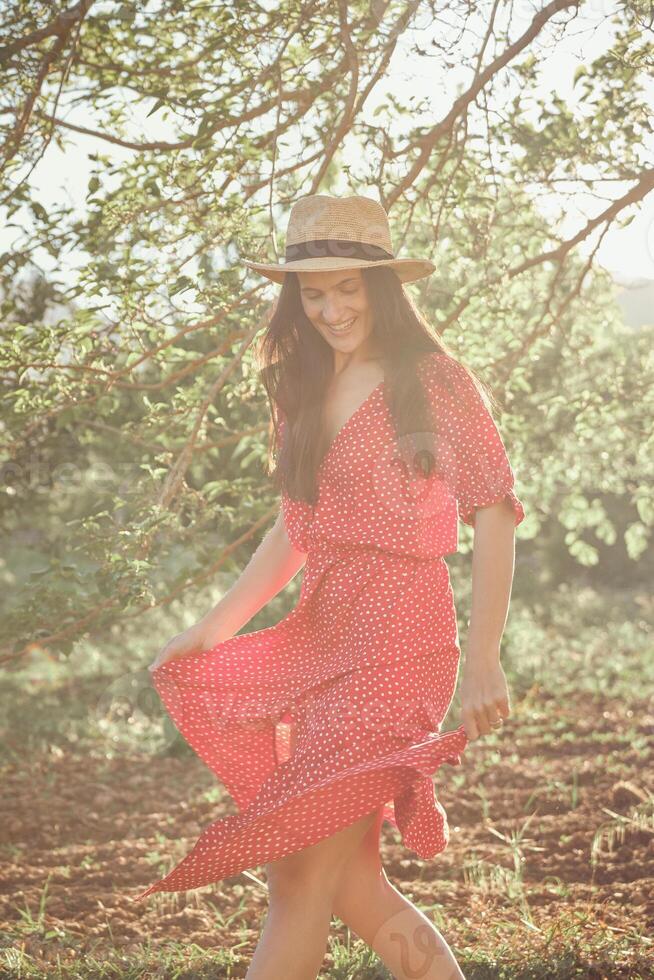 Happy woman in summer dress in park photo