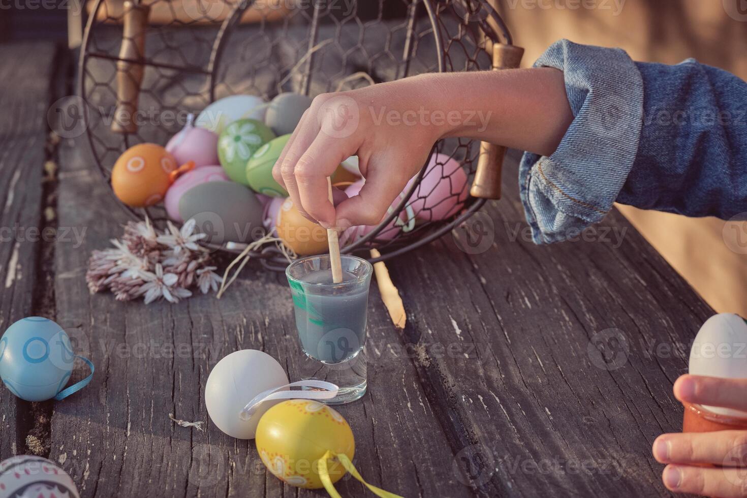 Easter eggs painted by kid on wooden table photo