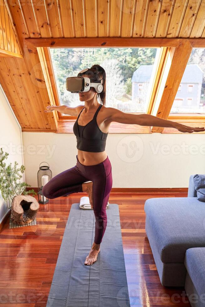 Female in headset balancing in Mountain pose with spread arms photo