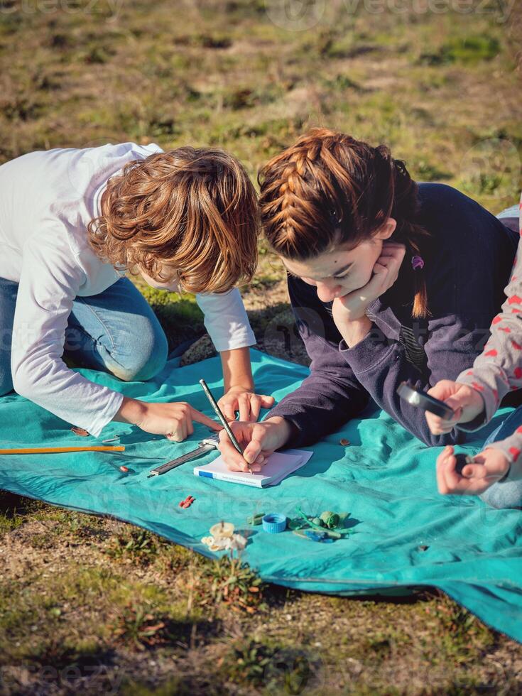Focused teen children exploring assorted garbage and plastic was photo