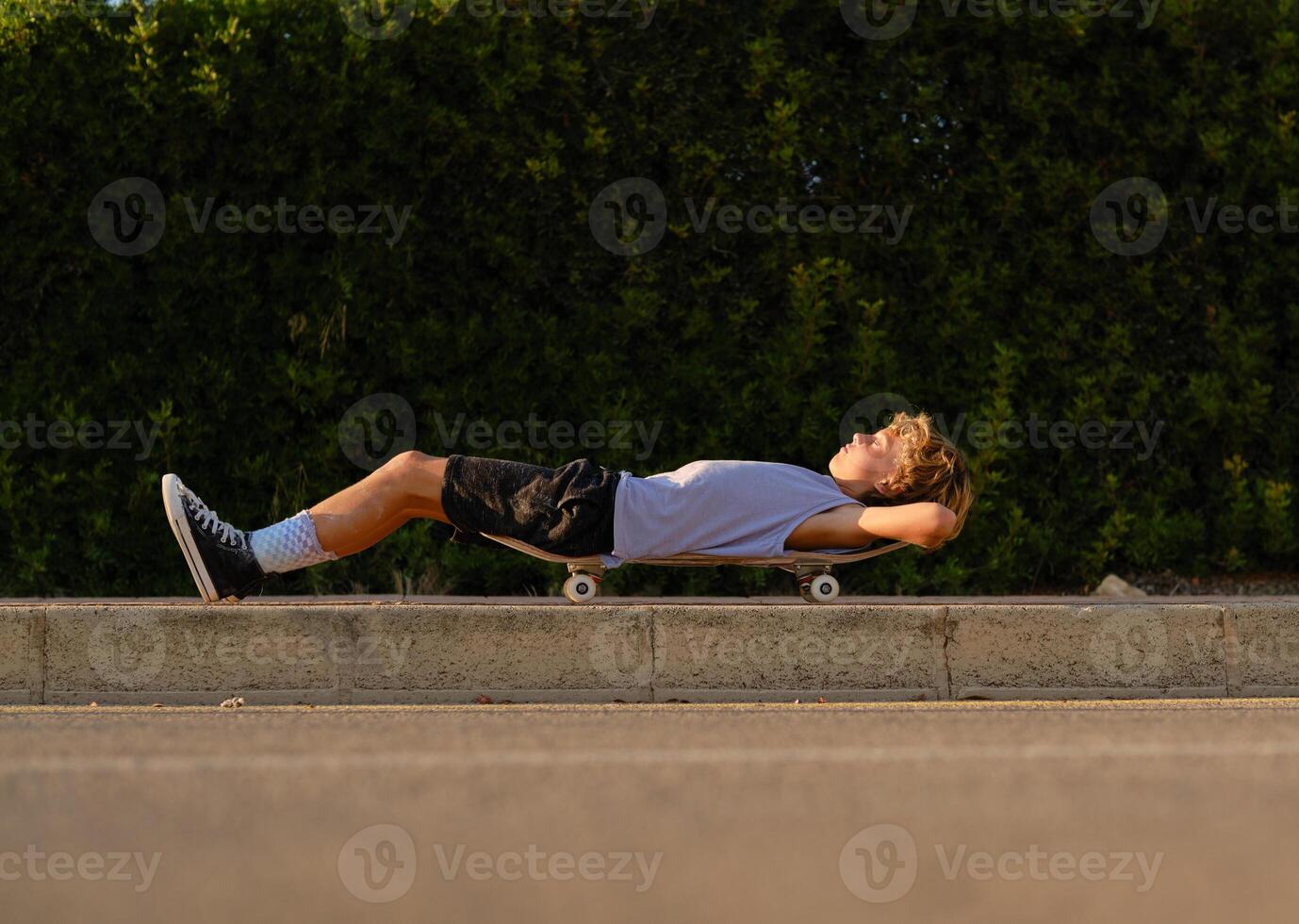 Carefree skater lying on skateboard in city photo