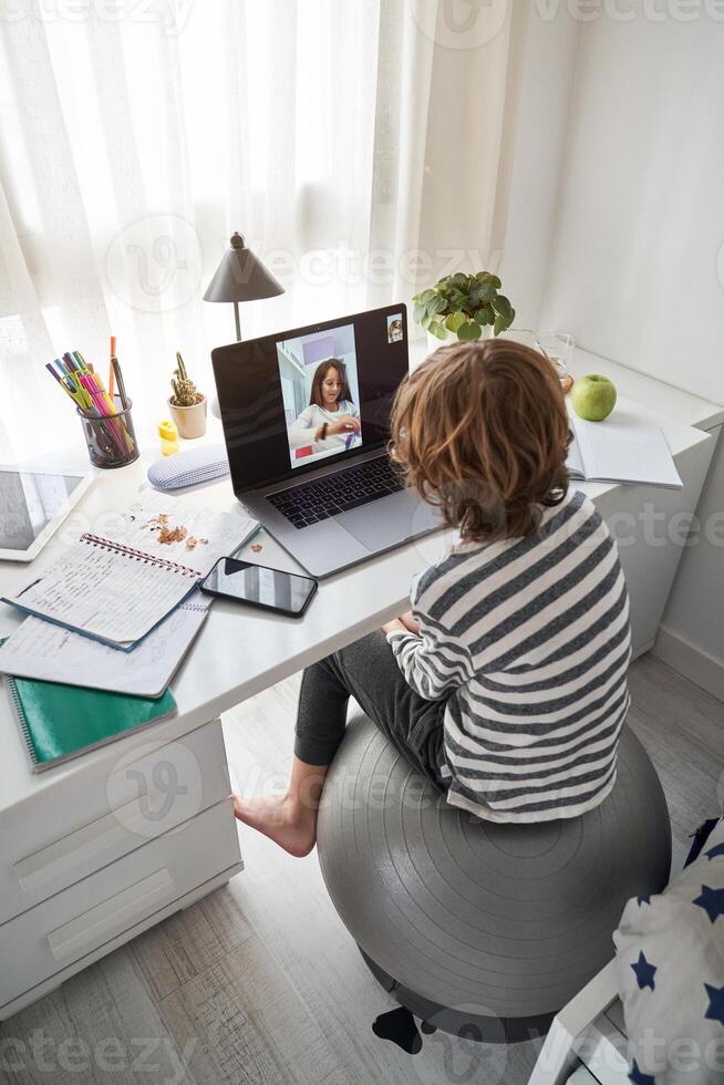 Anonymous boy chatting with classmate during schoolwork photo