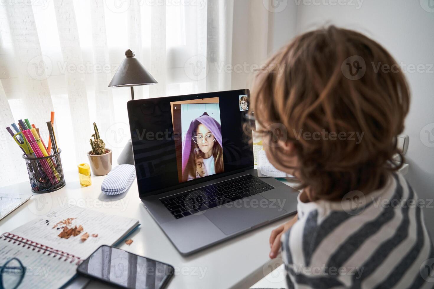 Anonymous boy making call with classmate photo