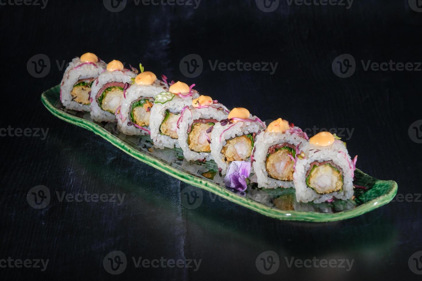 Appetizing uramaki rolls served with sauce on marble tray photo