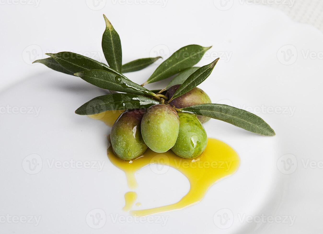 Green olives and leaves on plate photo