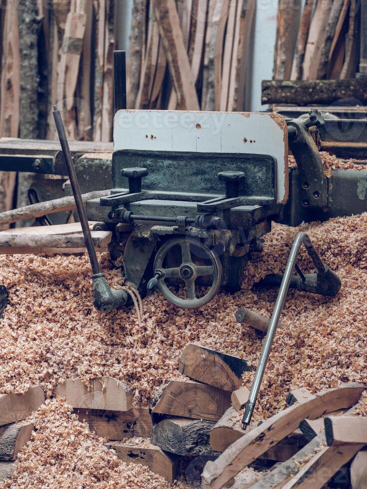 Lathe near heap of wood photo