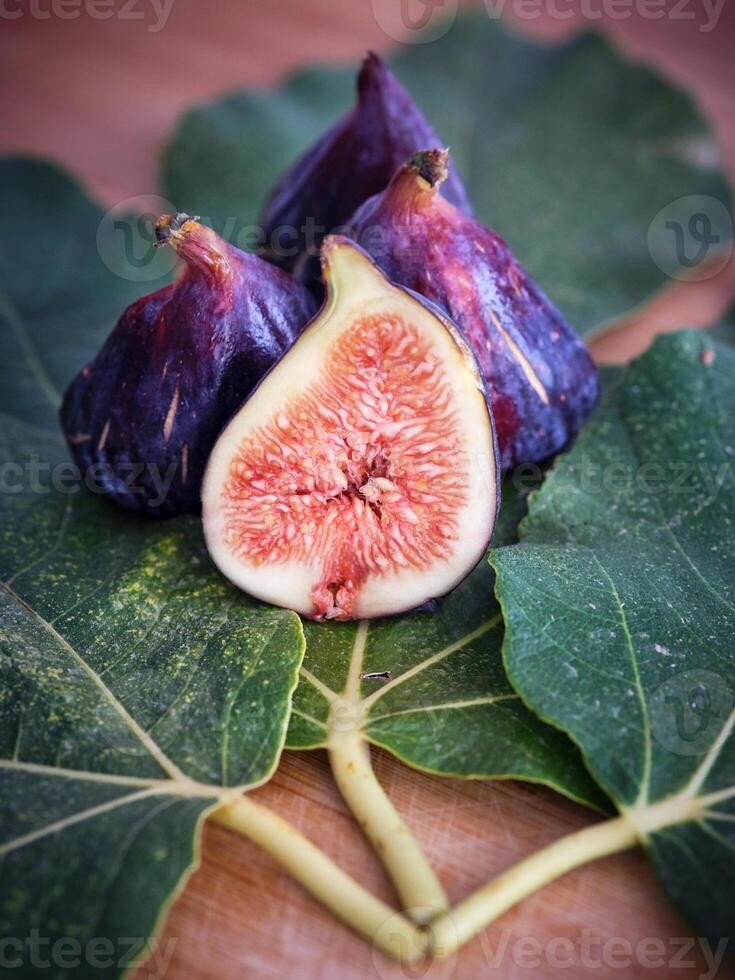 Halved and whole figs on sycamine leaves photo