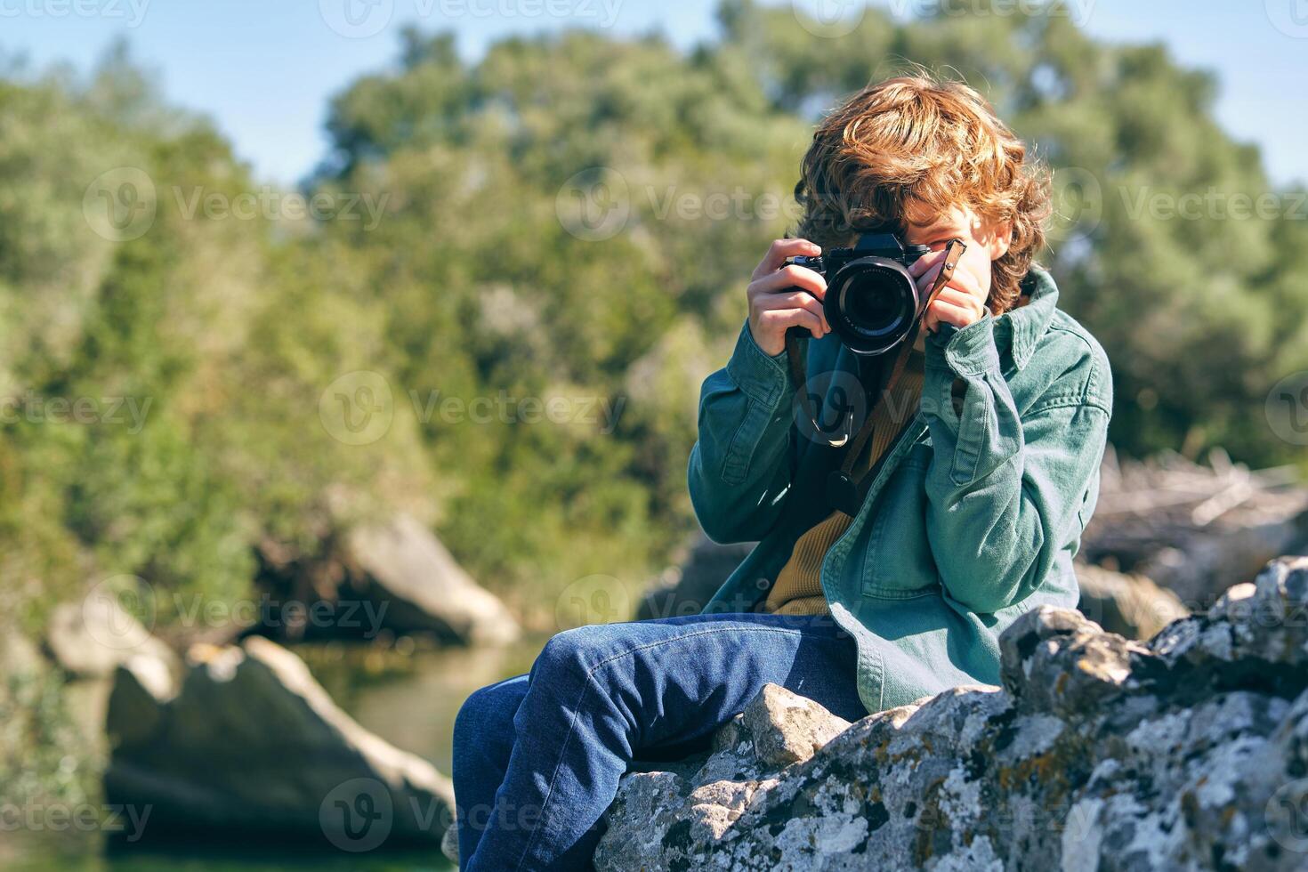 Unrecognizable boy taking photo on coast