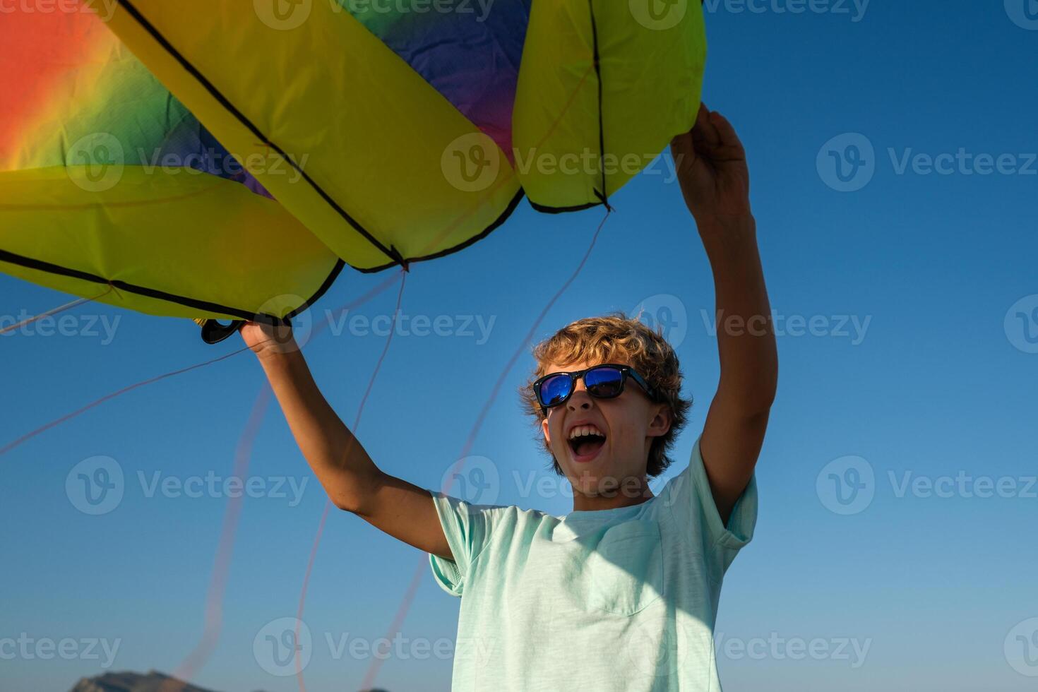 Excited boy with rainbow kite photo